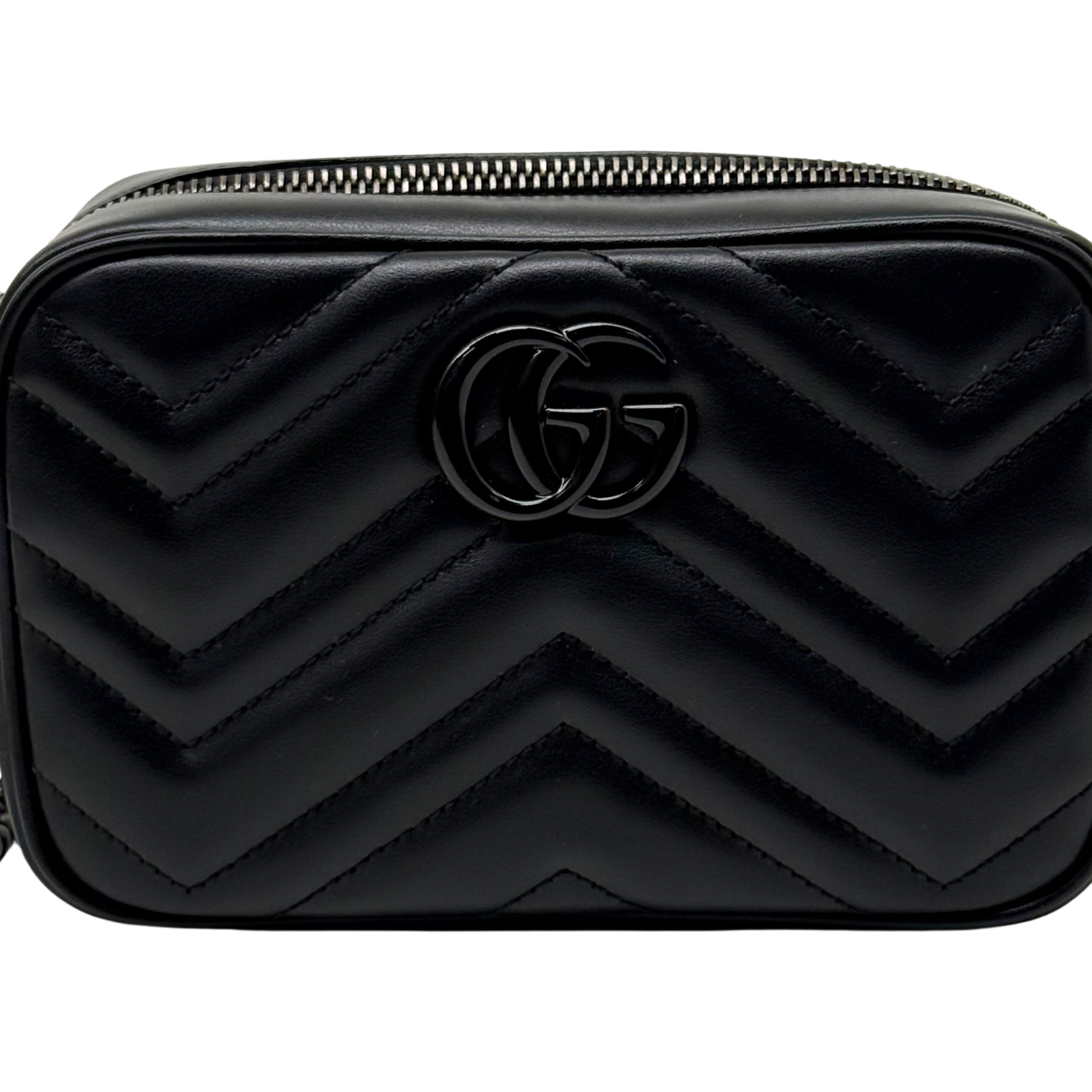 Black leather mini bag with embossed GG logo and chevron quilt, close-up front.