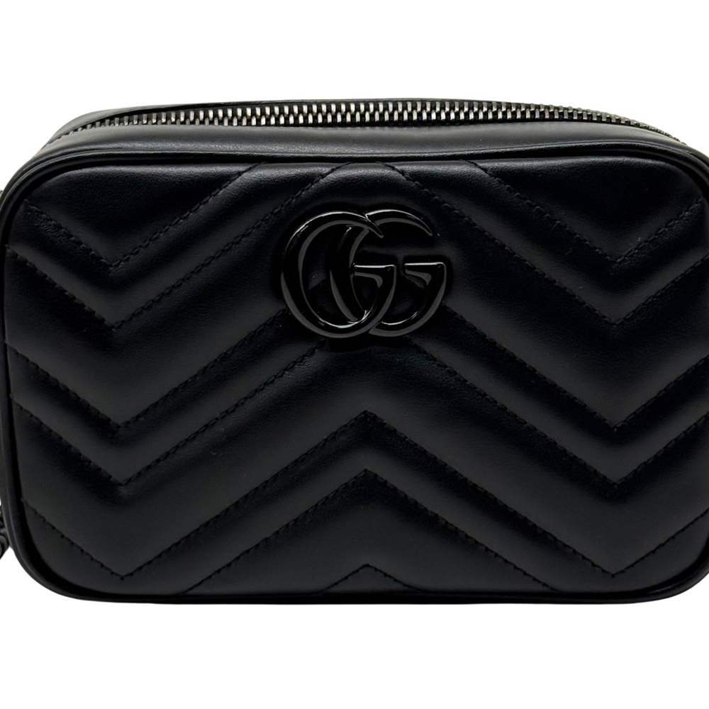 Black leather mini bag with embossed GG logo and chevron quilt, close-up front.