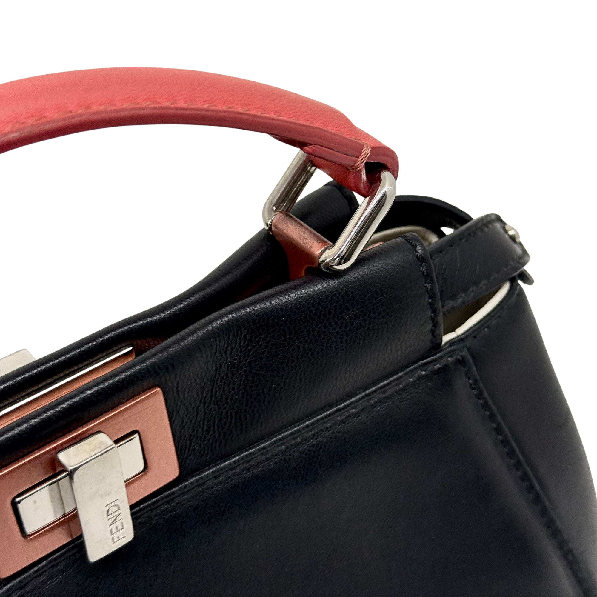 Red-and-black top handle with silver ring and lock hardware on black leather bag