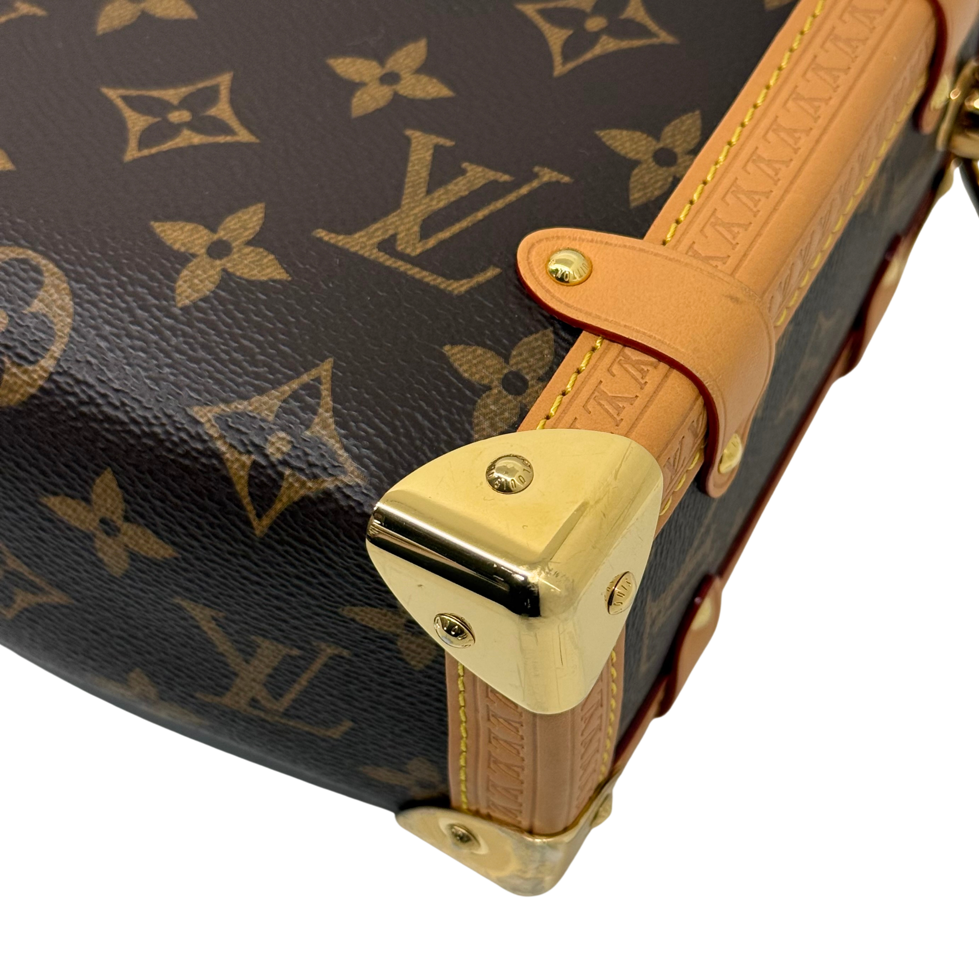 Louis Vuitton monogram handbag corner with tan leather flap and gold-tone lock