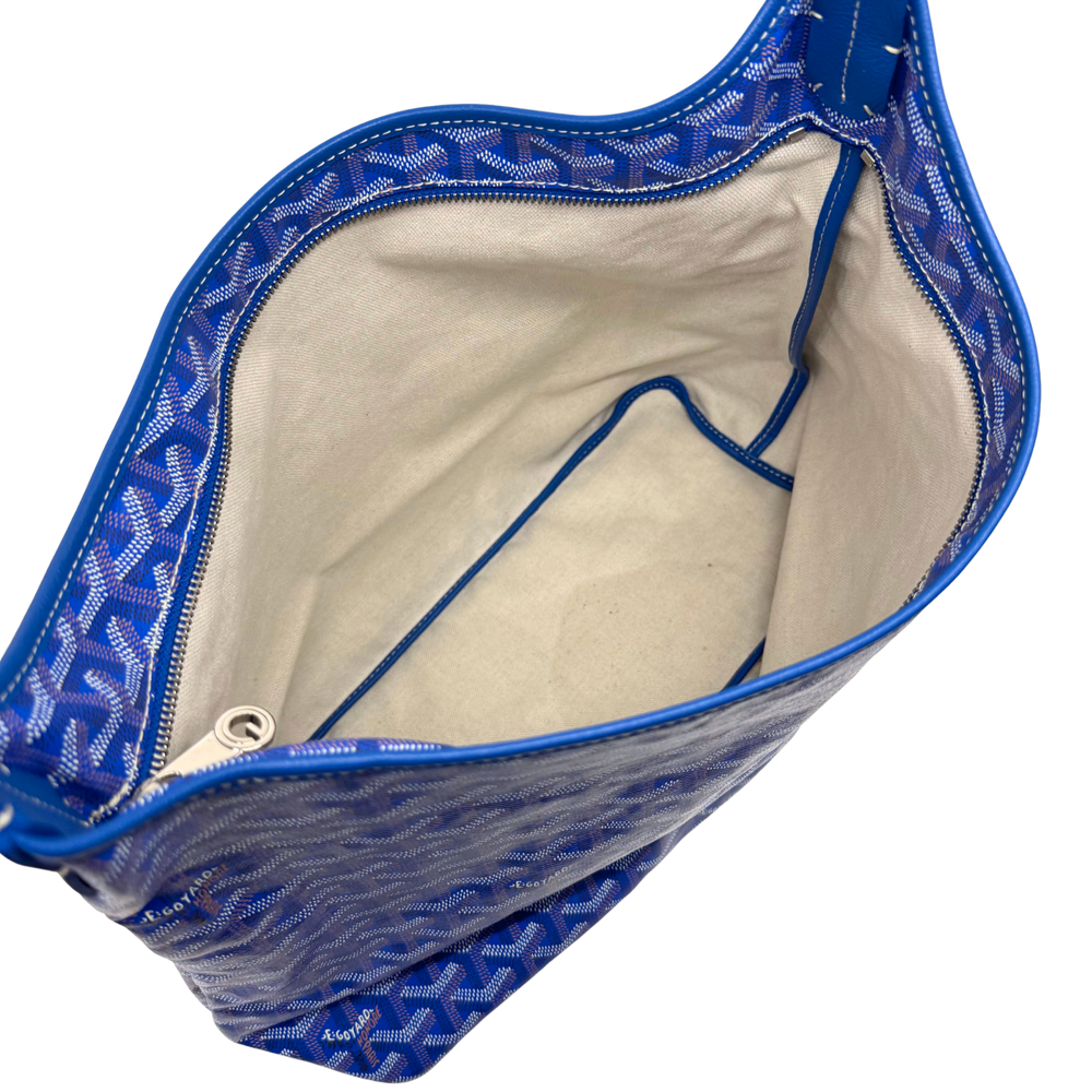 Open blue handbag with cream lining, interior cords, and curved top edge