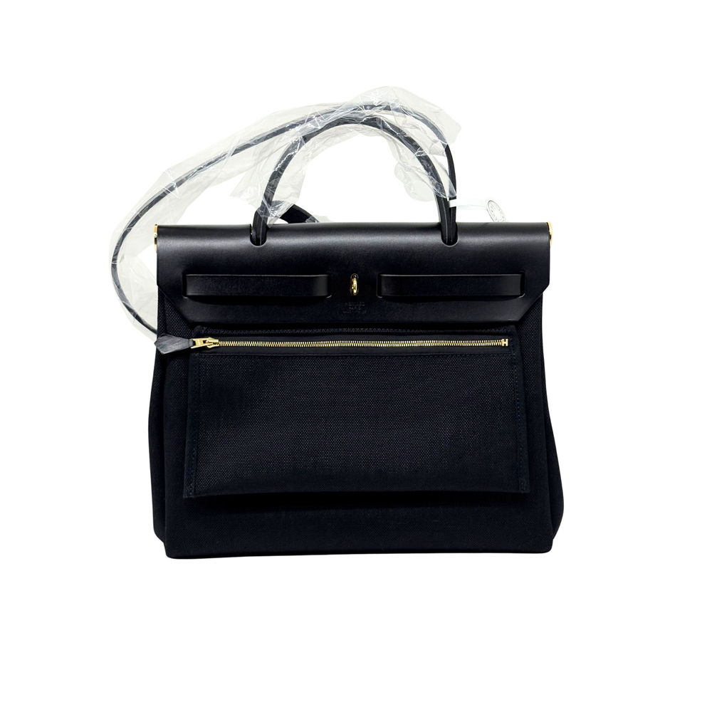 Hermes black leather handbag with top handles, front flap, and gold zipper