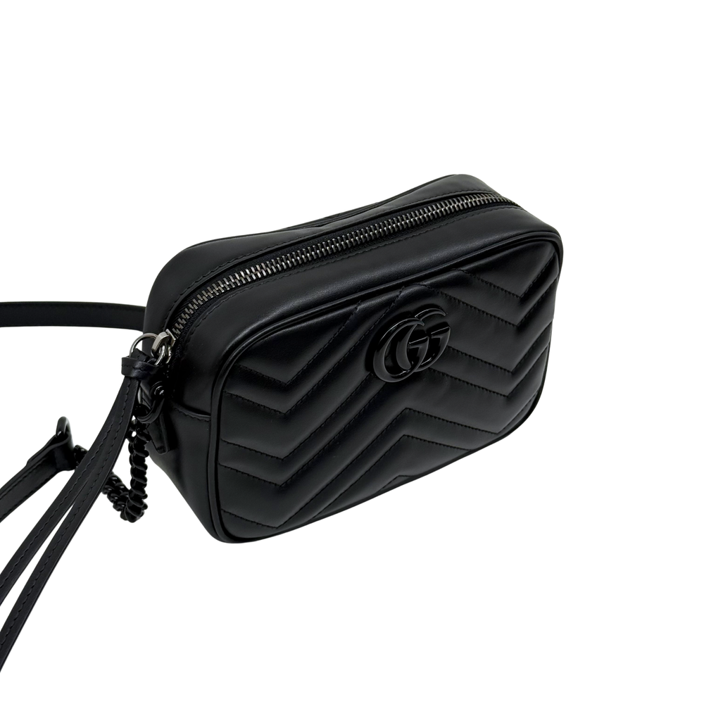 Black leather crossbody bag with chevron pattern, top zipper and GG logo, side view.