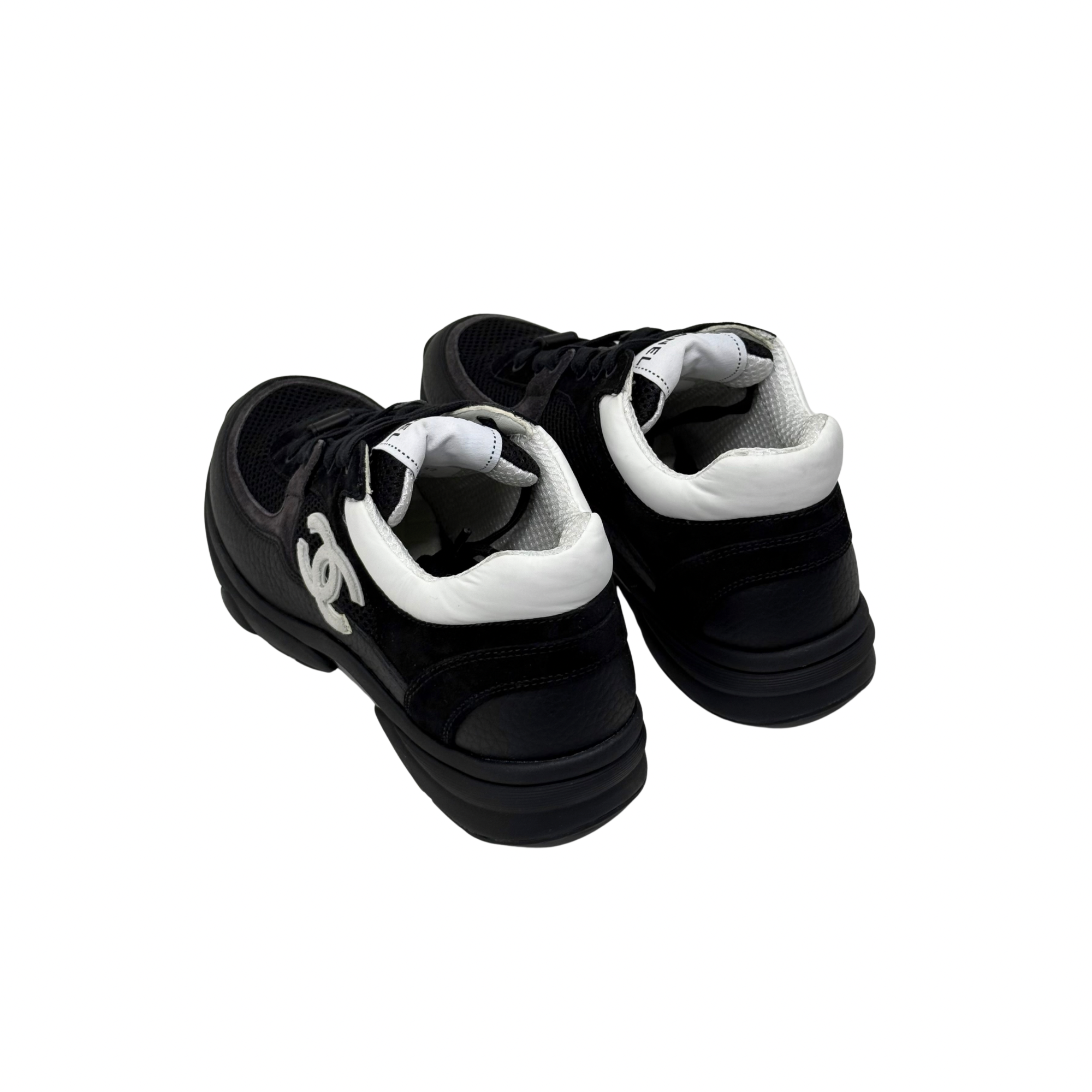 Black low-top sneakers with white inner lining and logo detail on heel.