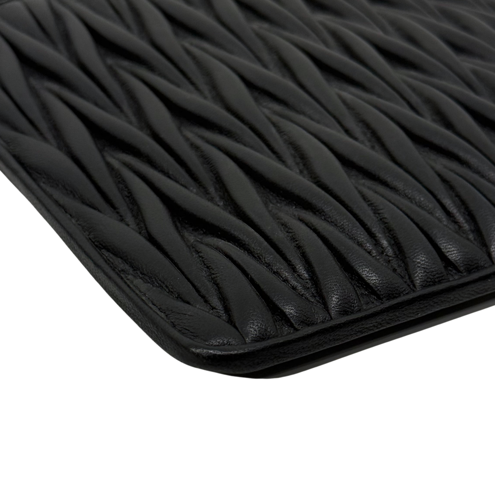 Black leather bag front with quilted ridges texture and curved edge