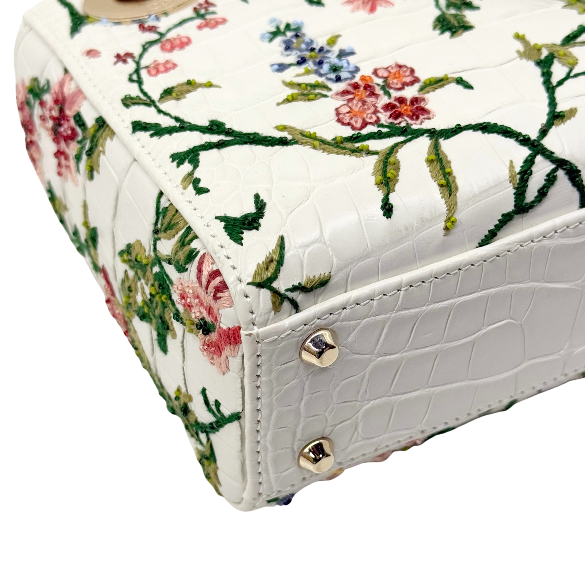 White floral mini handbag side panel with gold snap fastener and embossed texture