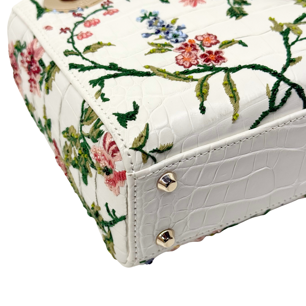 White floral mini handbag side panel with gold snap fastener and embossed texture