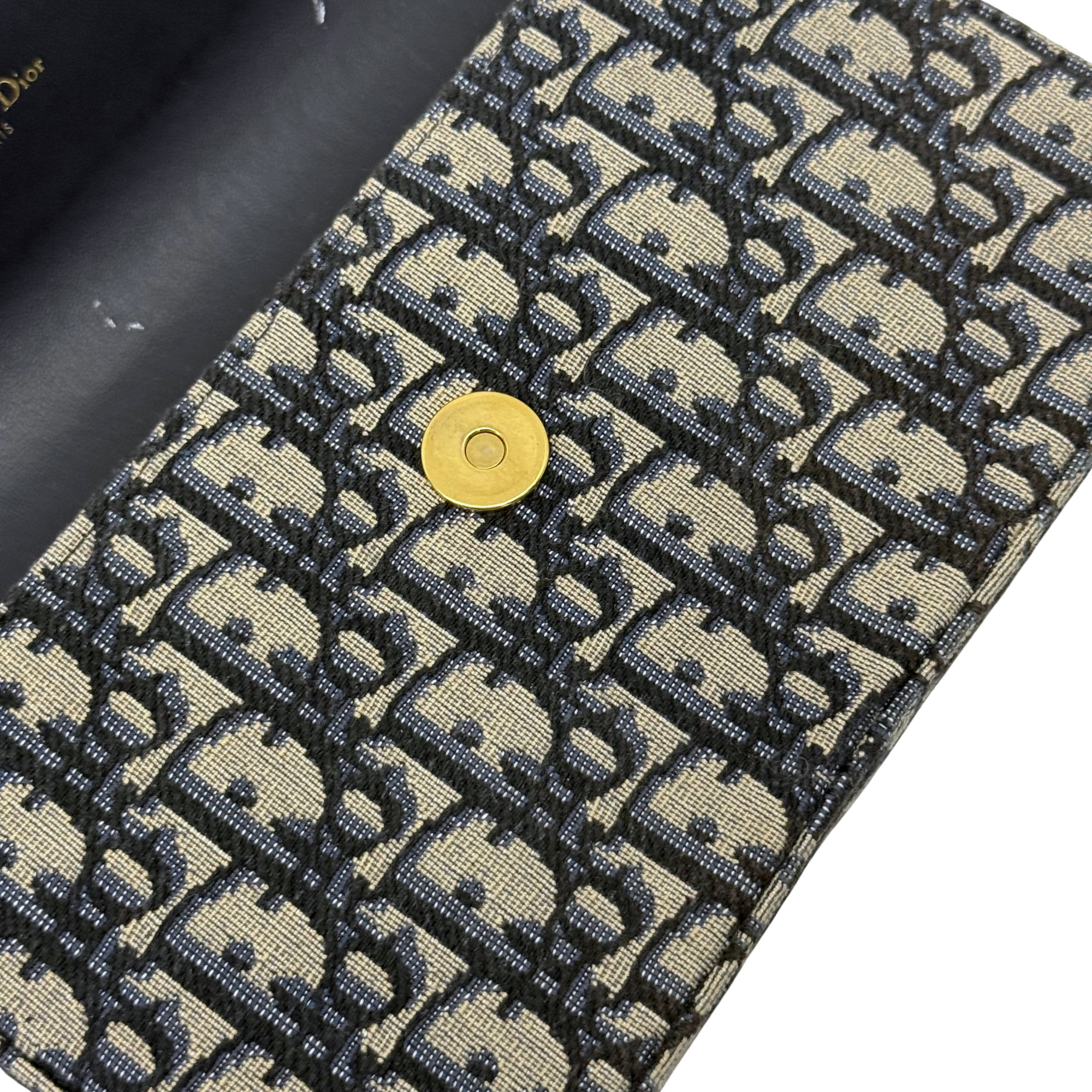 Dior monogram bag corner with gold snap button and woven canvas texture