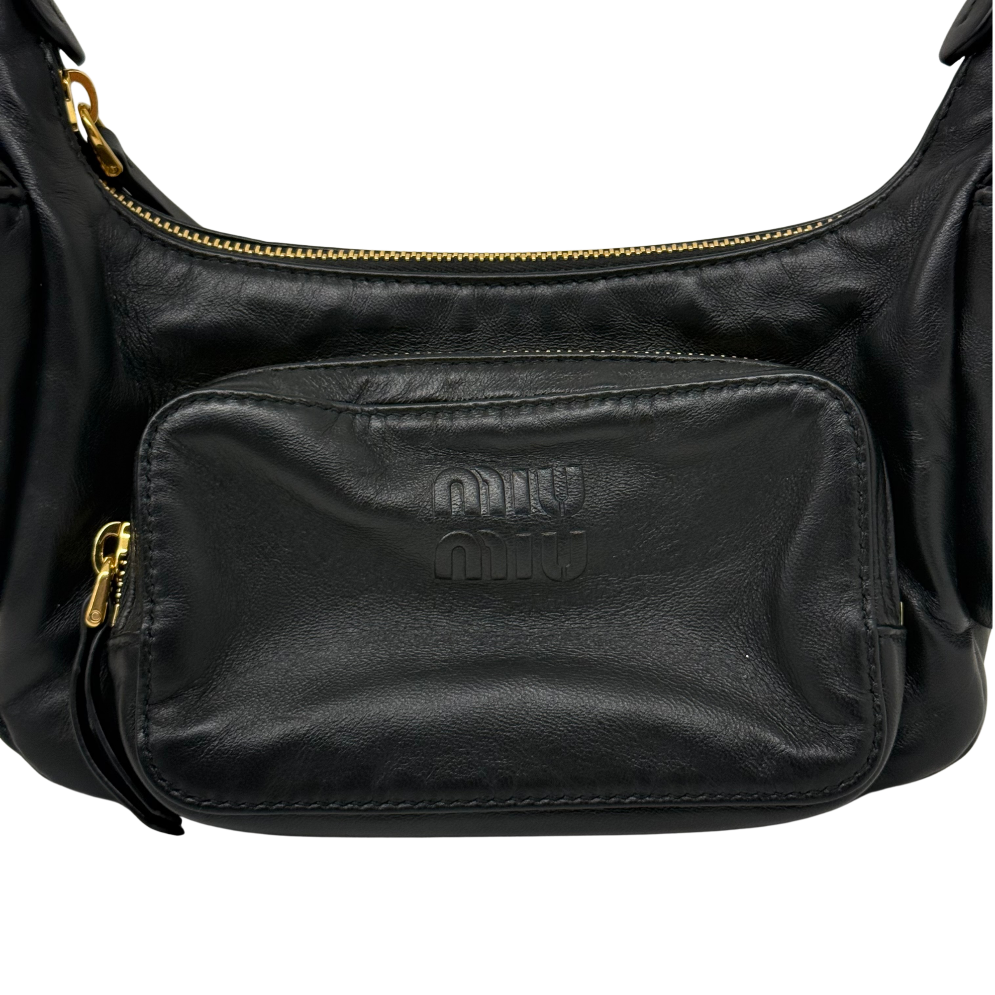 Black leather shoulder bag front pocket with embossed logo and gold zipper pull