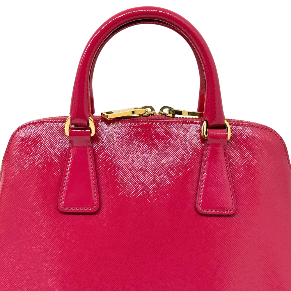 Prada pink handbag top view with two handles and gold clasp hardware