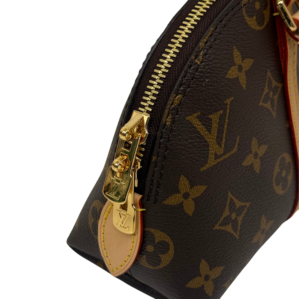Monogram bag side close-up with gold zipper and key hardware