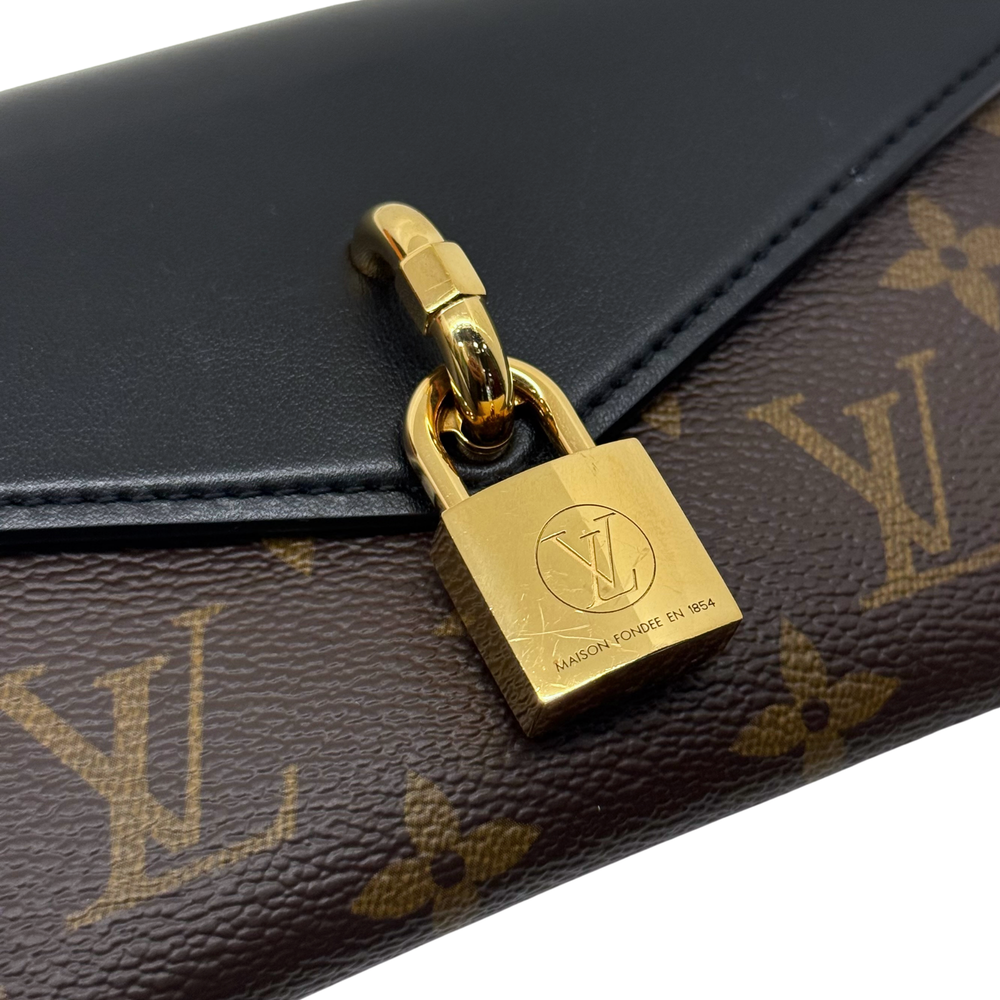 Gold padlock charm on black flap over brown monogram canvas