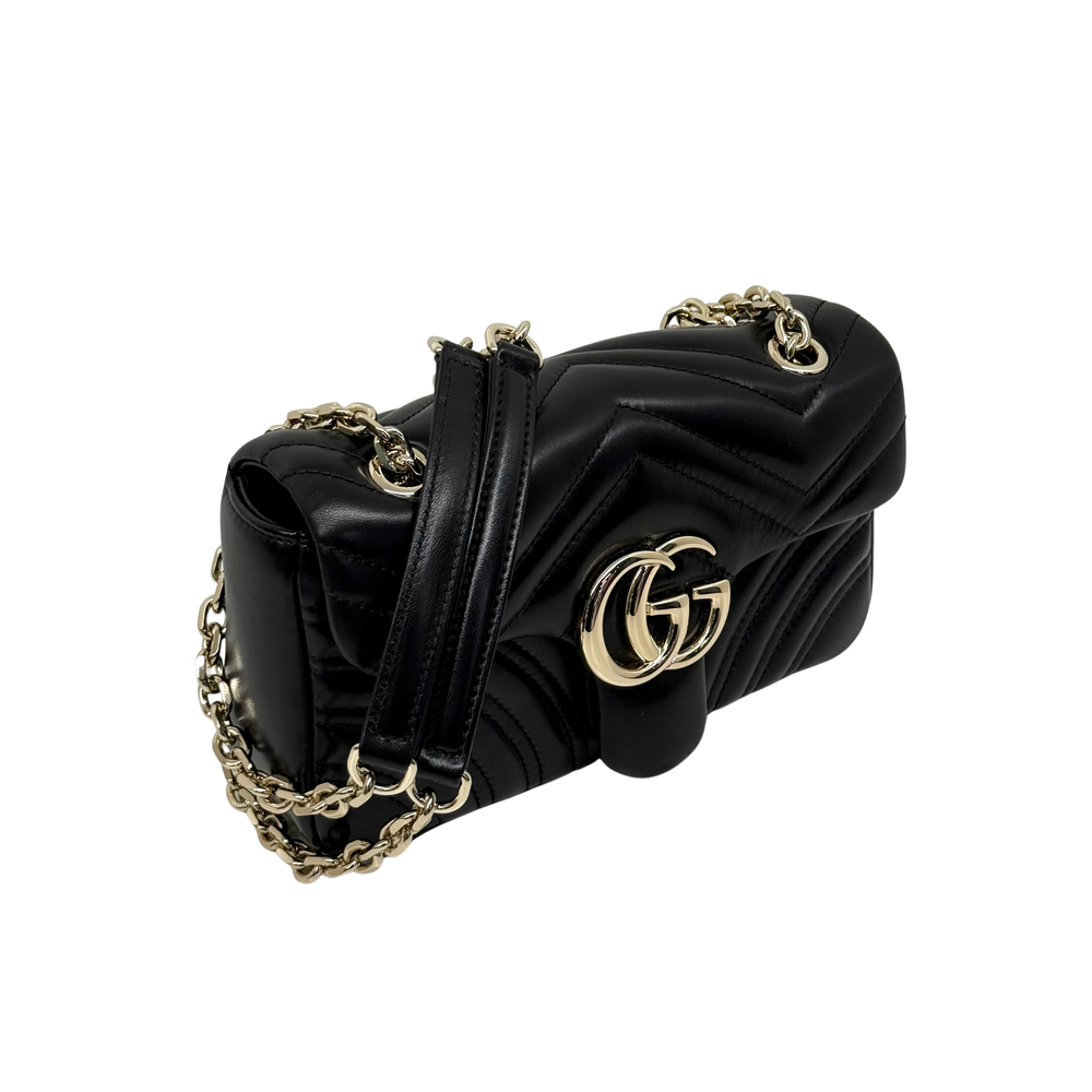 Gucci shoulder bag side view with black chevron quilting, gold double-G logo, chain strap