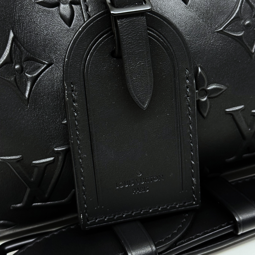 Louis Vuitton Paris embossed tag on black monogram crossbody bag, close-up