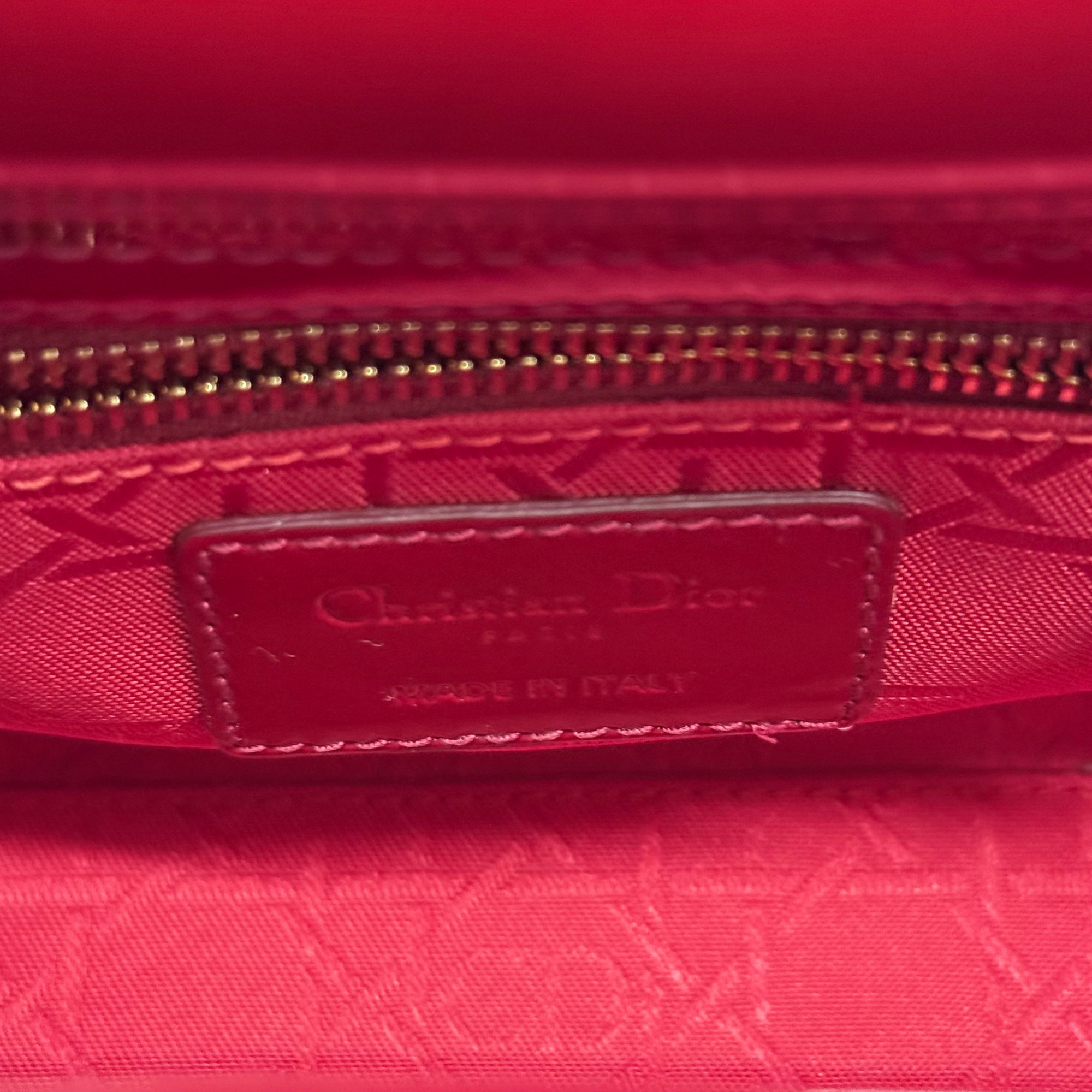 Red fabric interior lining with Dior logo patch inside the mini handbag