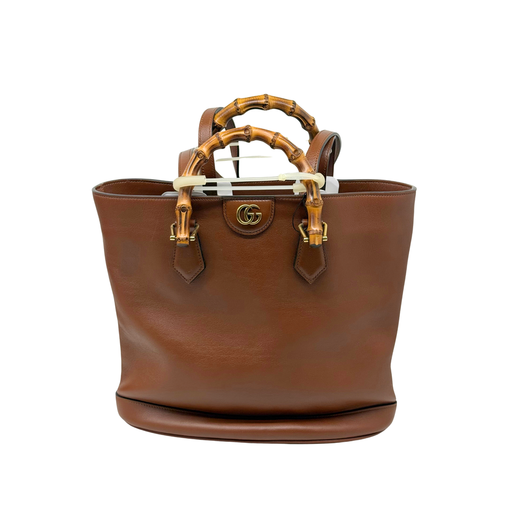 Leather bucket tote with bamboo handles and central GG logo medallion