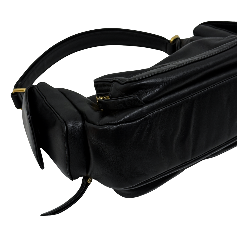 Black leather shoulder bag side view with rolled shape and curved top handle
