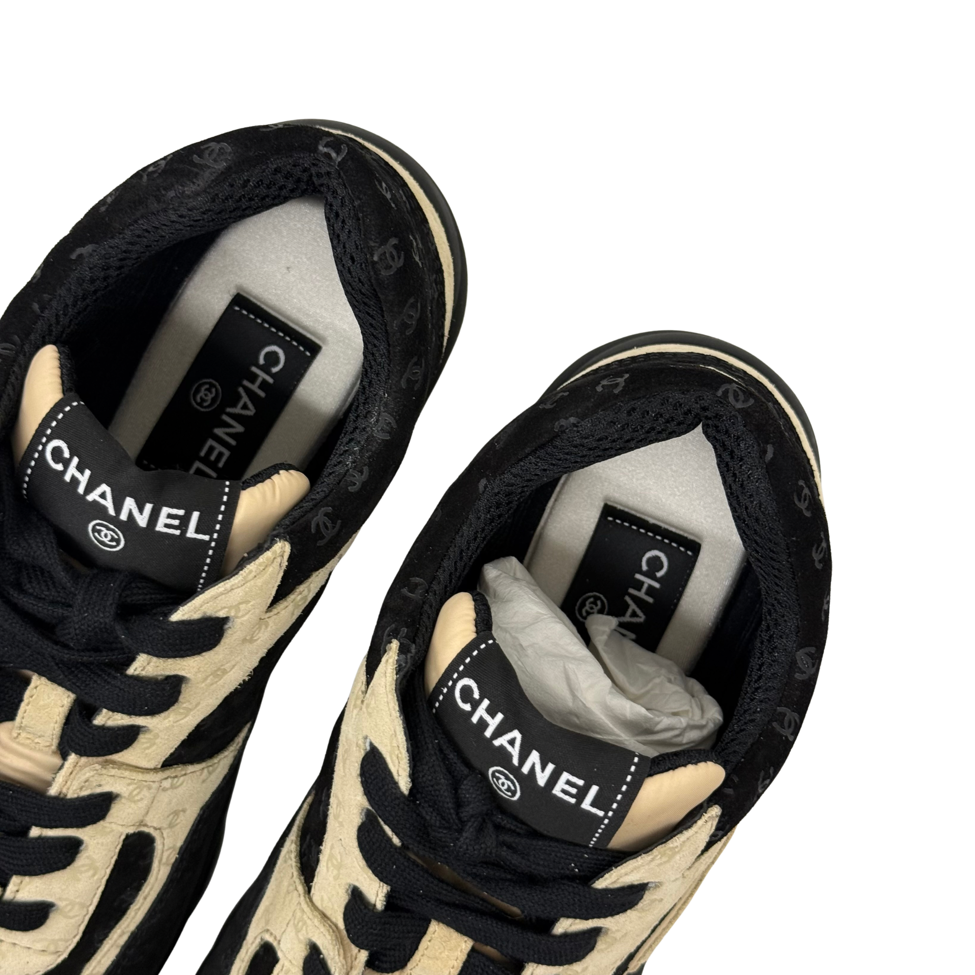 Black and beige Chanel sneakers, interior collar and tongue label visible