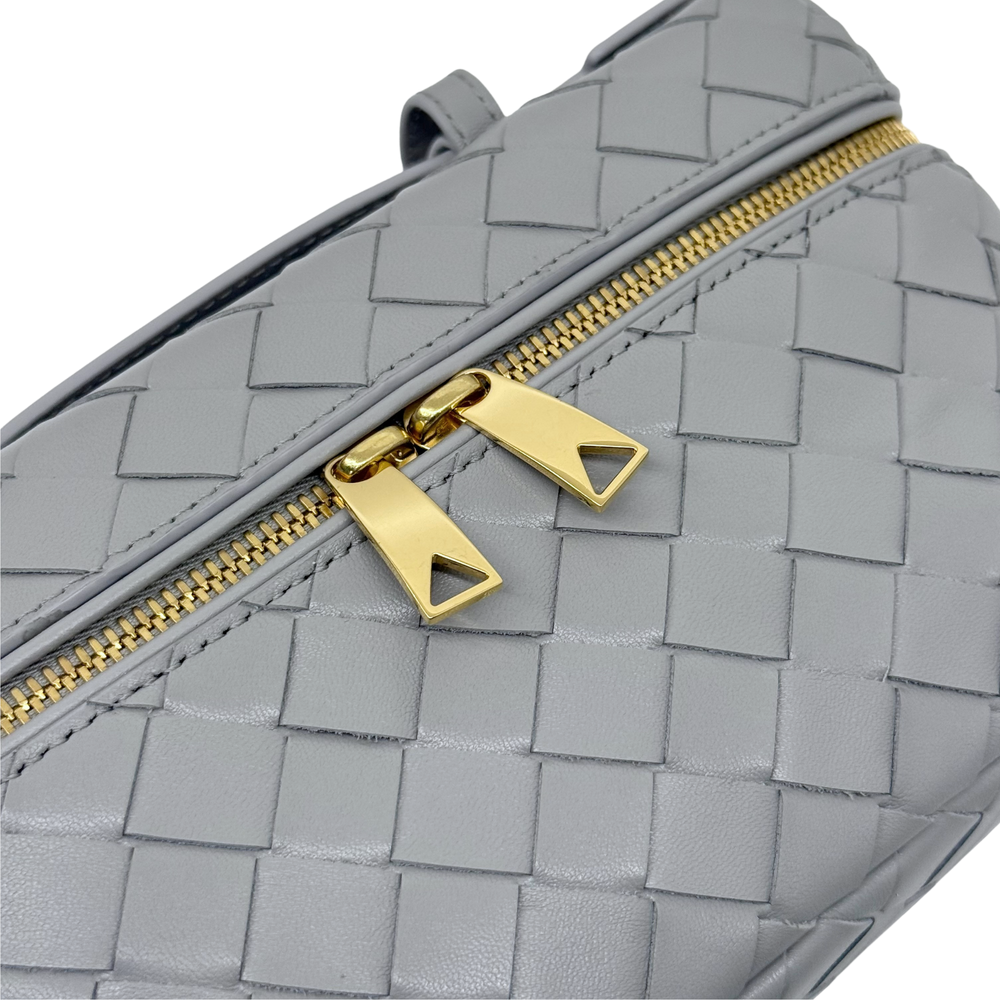 Bottega Veneta gray woven leather bag with gold zipper pulls and top edge trim.