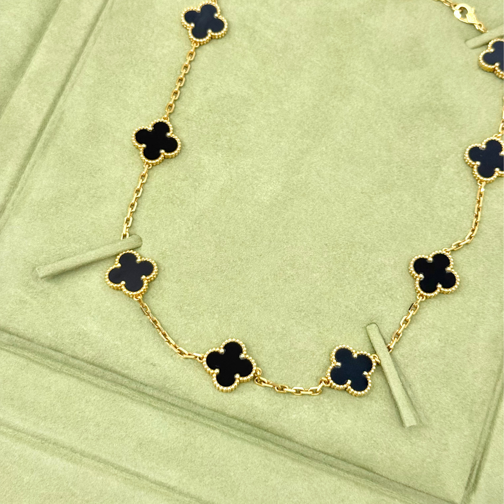 Van Cleef clover necklace with gold-tone chain and black four-leaf motif links