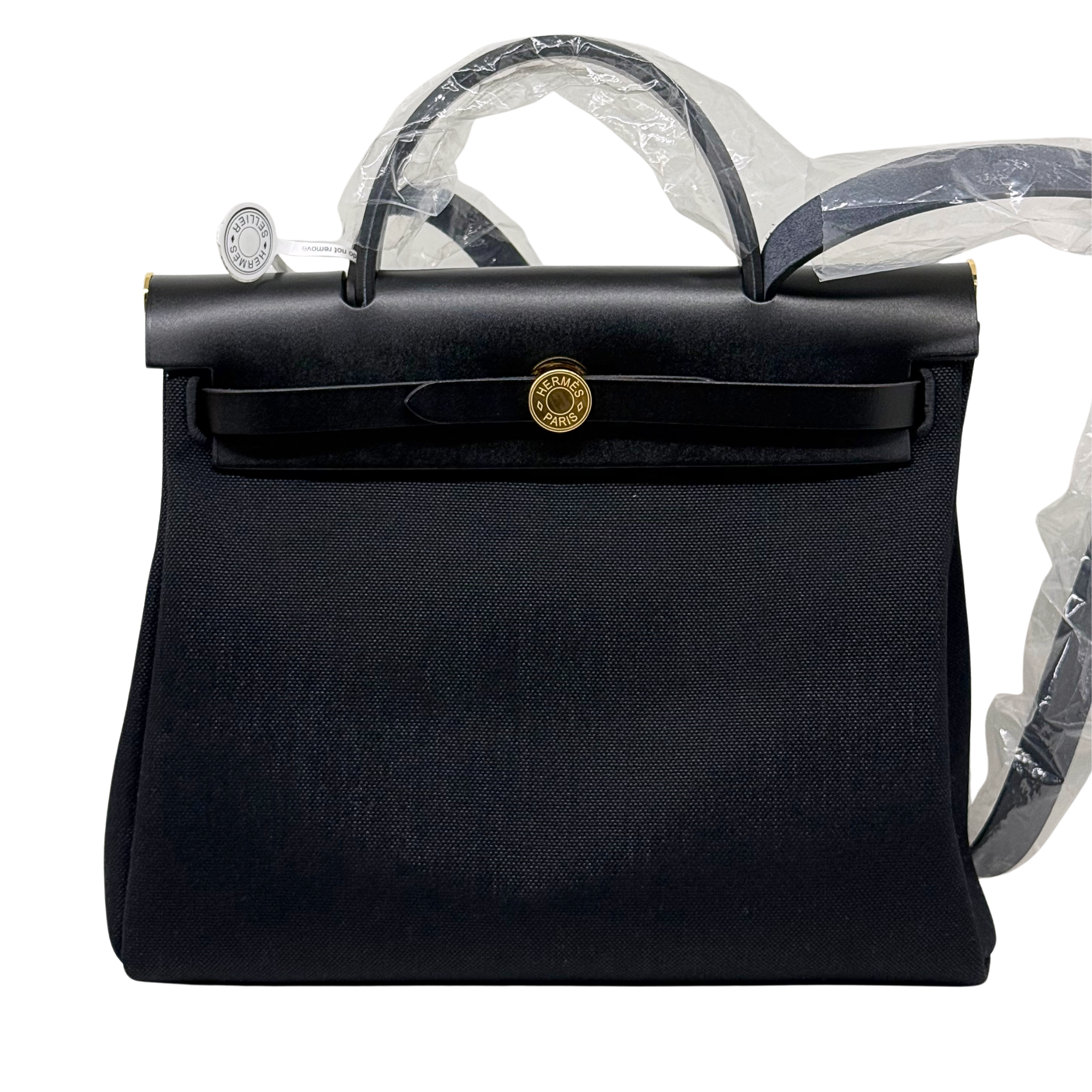 Hermes handbag front view with round gold clasp, textured body, and top handles