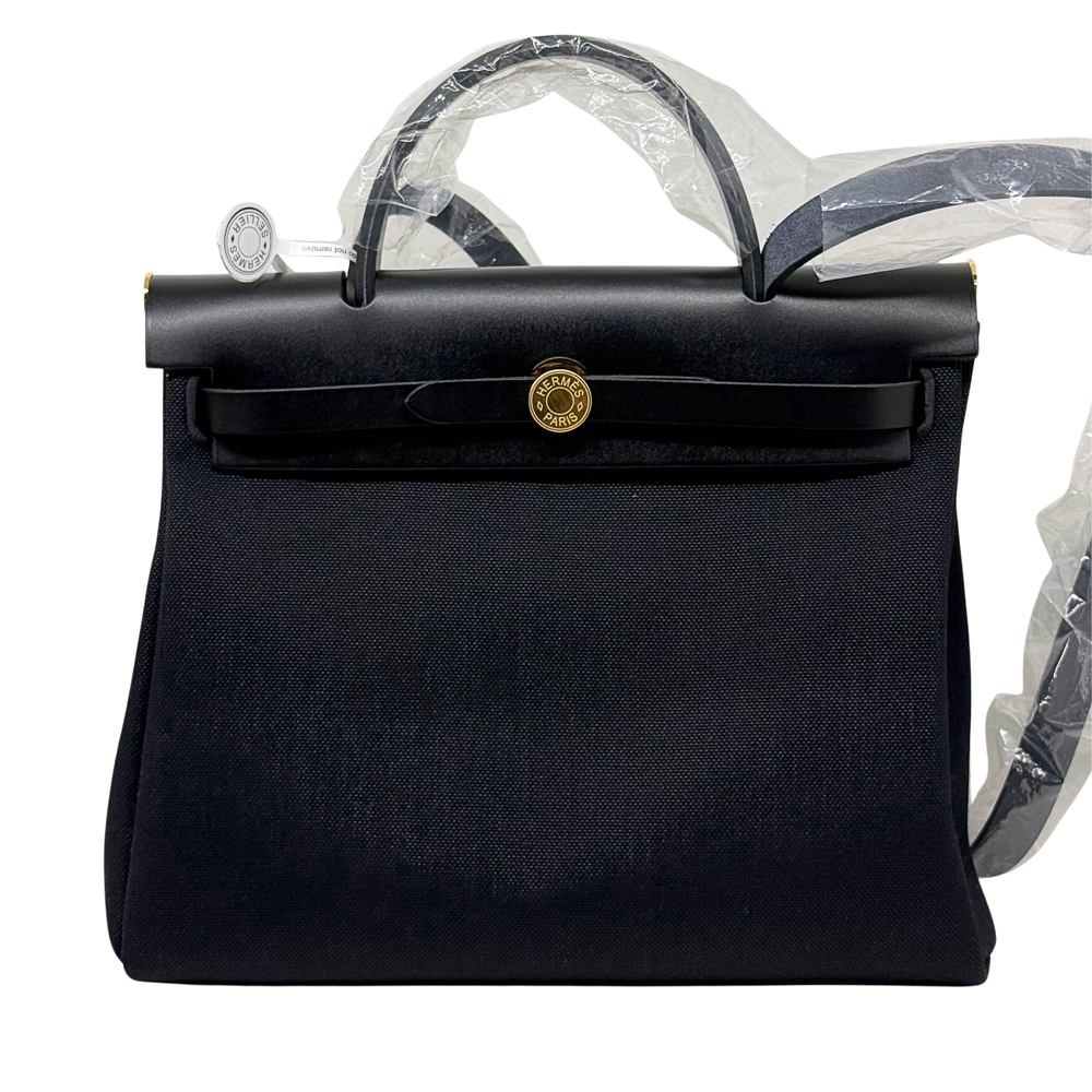 Hermes handbag front view with round gold clasp, textured body, and top handles