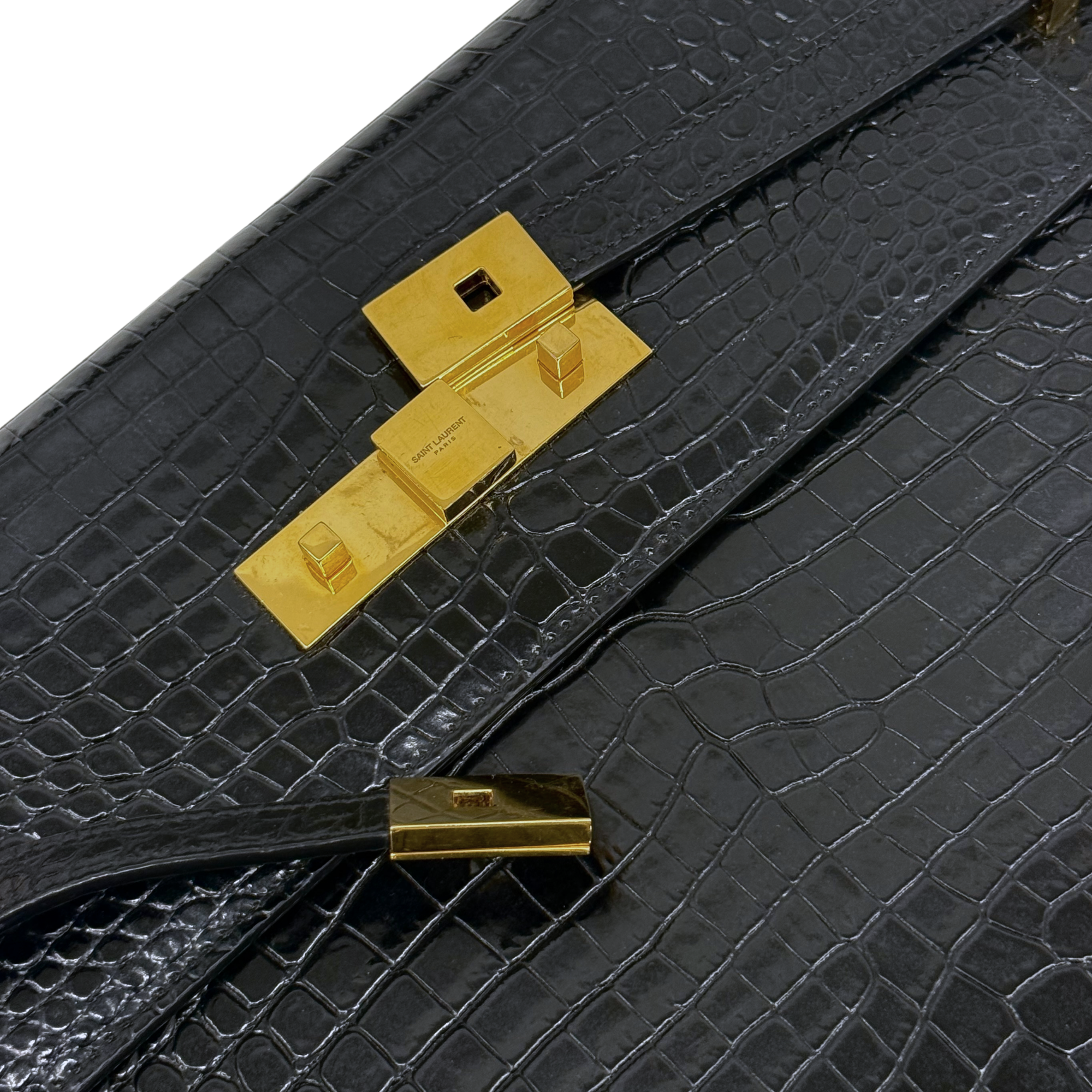 Black croc-embossed leather bag strap detail with gold-tone clasp