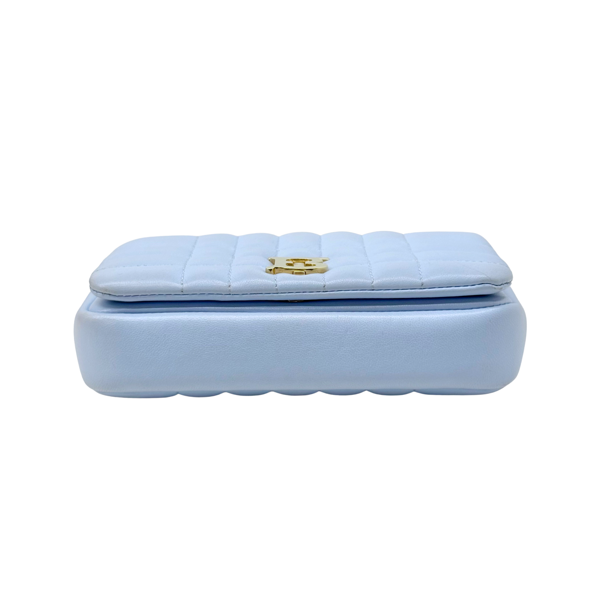 Light blue quilted clutch-style shoulder bag with gold central B emblem clasp.