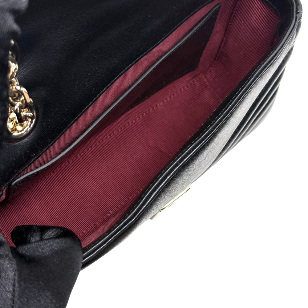 Gucci shoulder bag interior with burgundy lining and black leather trim along edge