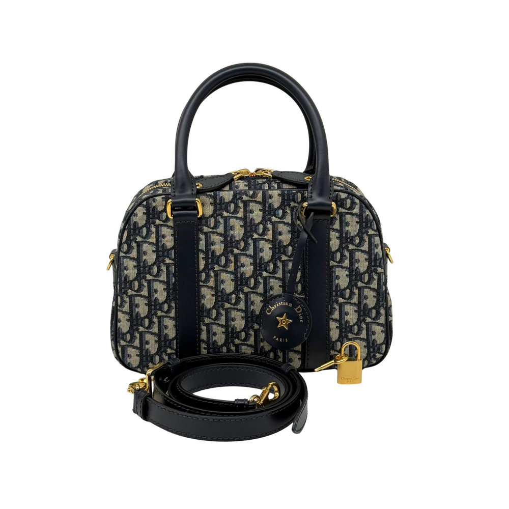 Navy and cream monogram handbag with top handles, front charm, and detachable strap