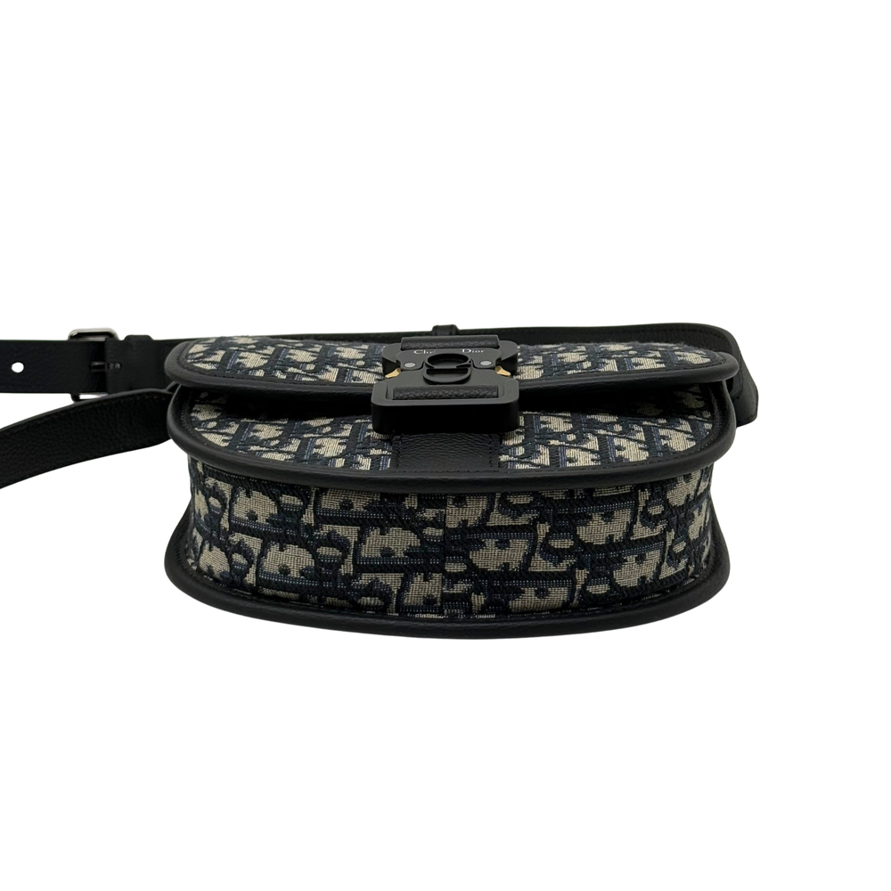 Dior mini crossbody bag with patterned canvas flap, buckle hardware, and strap