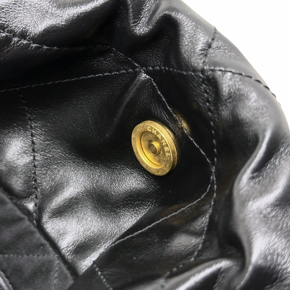 Black leather with round gold CHANEL snap button and quilted seam detail