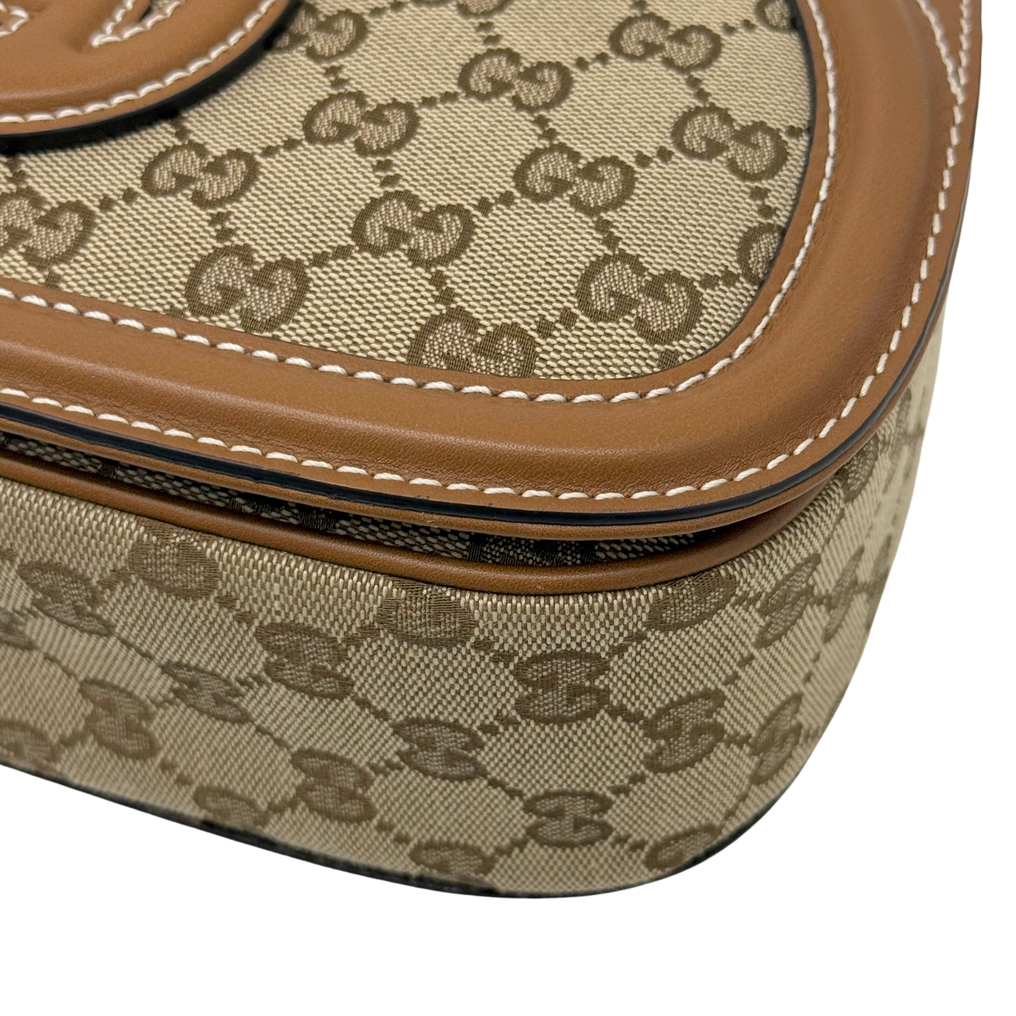 Gucci GG canvas bag corner closeup with brown leather piping and contrast stitching