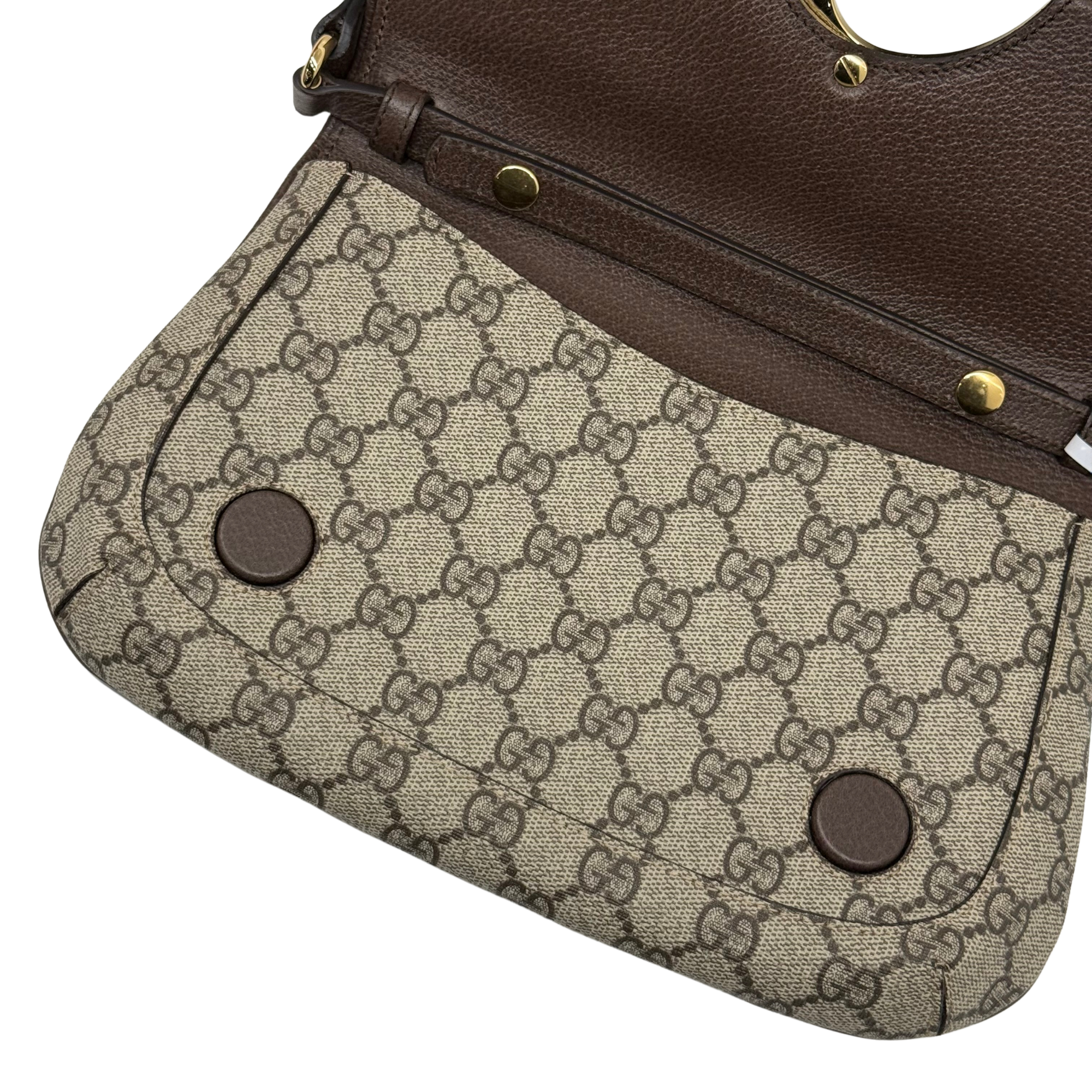 Gucci GG canvas flap bag underside with brown leather strap hardware and round magnetic snaps