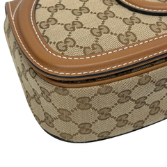 Gucci GG canvas corner with brown leather edge stitching and black trim strip