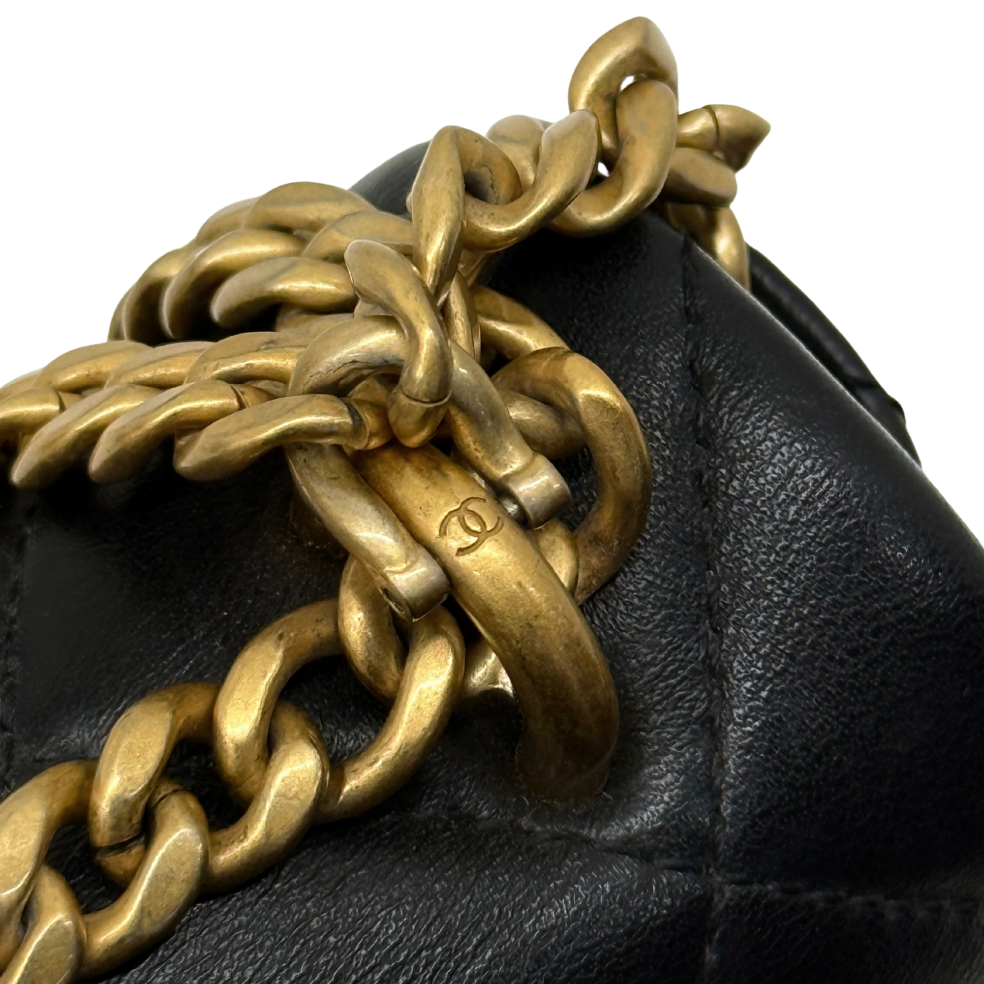 Black leather flap with gold-tone chain and interlocking links hardware detail