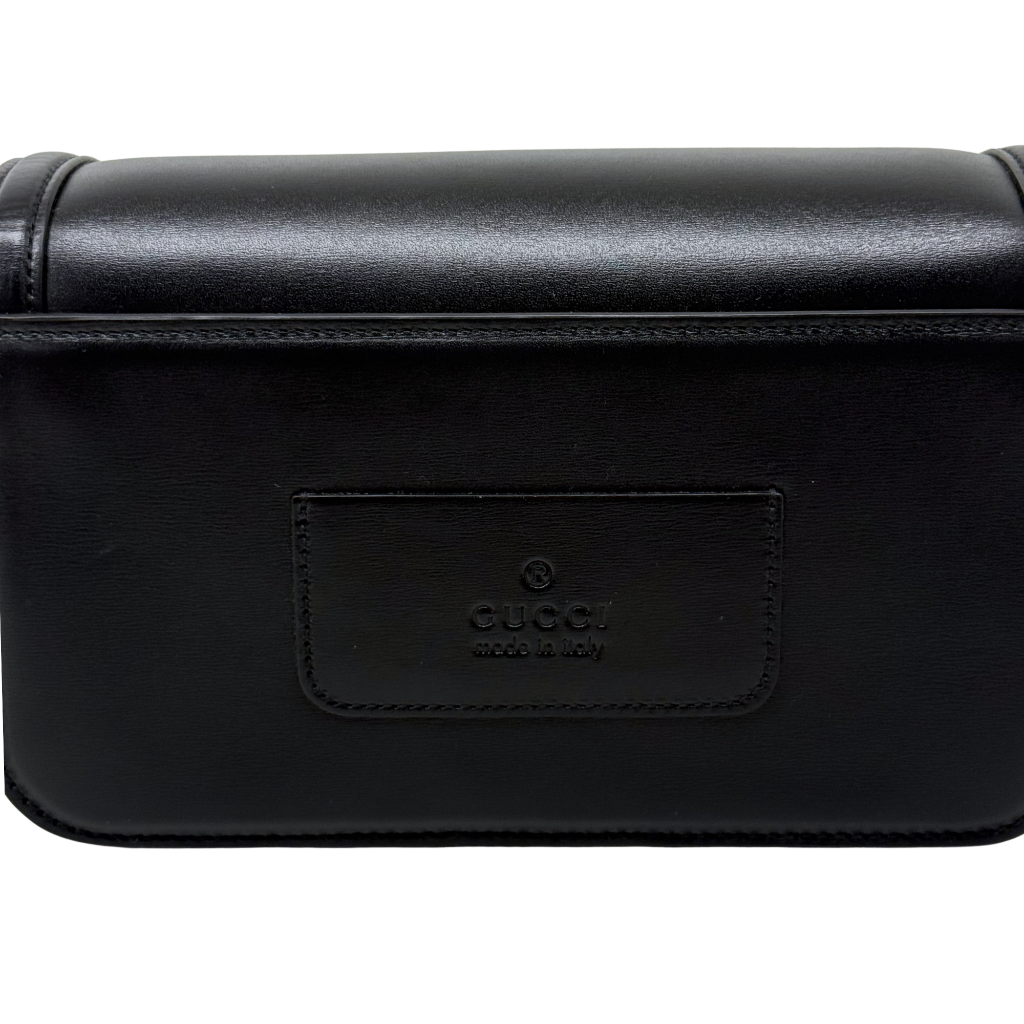 Black leather bag with embossed logo patch on the front flap