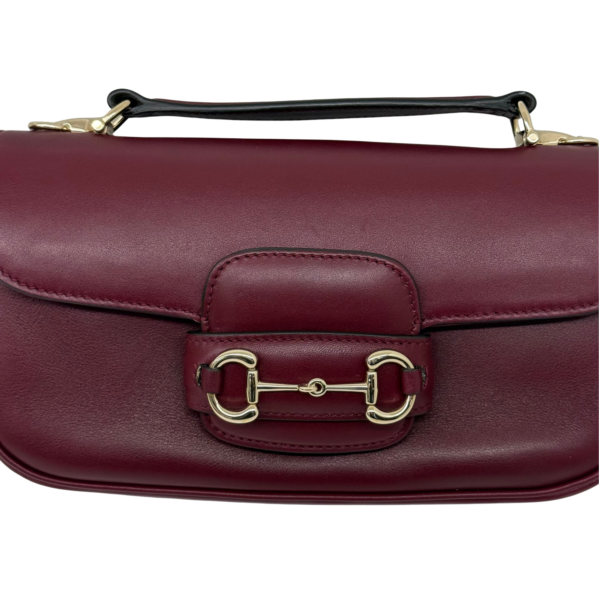 Maroon leather mini bag close-up of front buckle clasp hardware