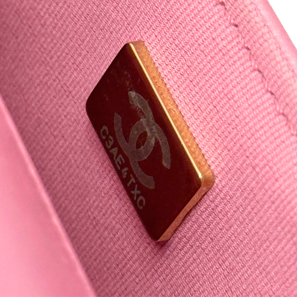 Gold microchip label on pink quilted leather bag interior lining