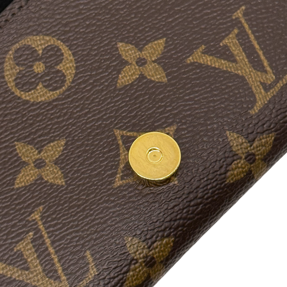 Gold snap button on brown monogram canvas with textured grain