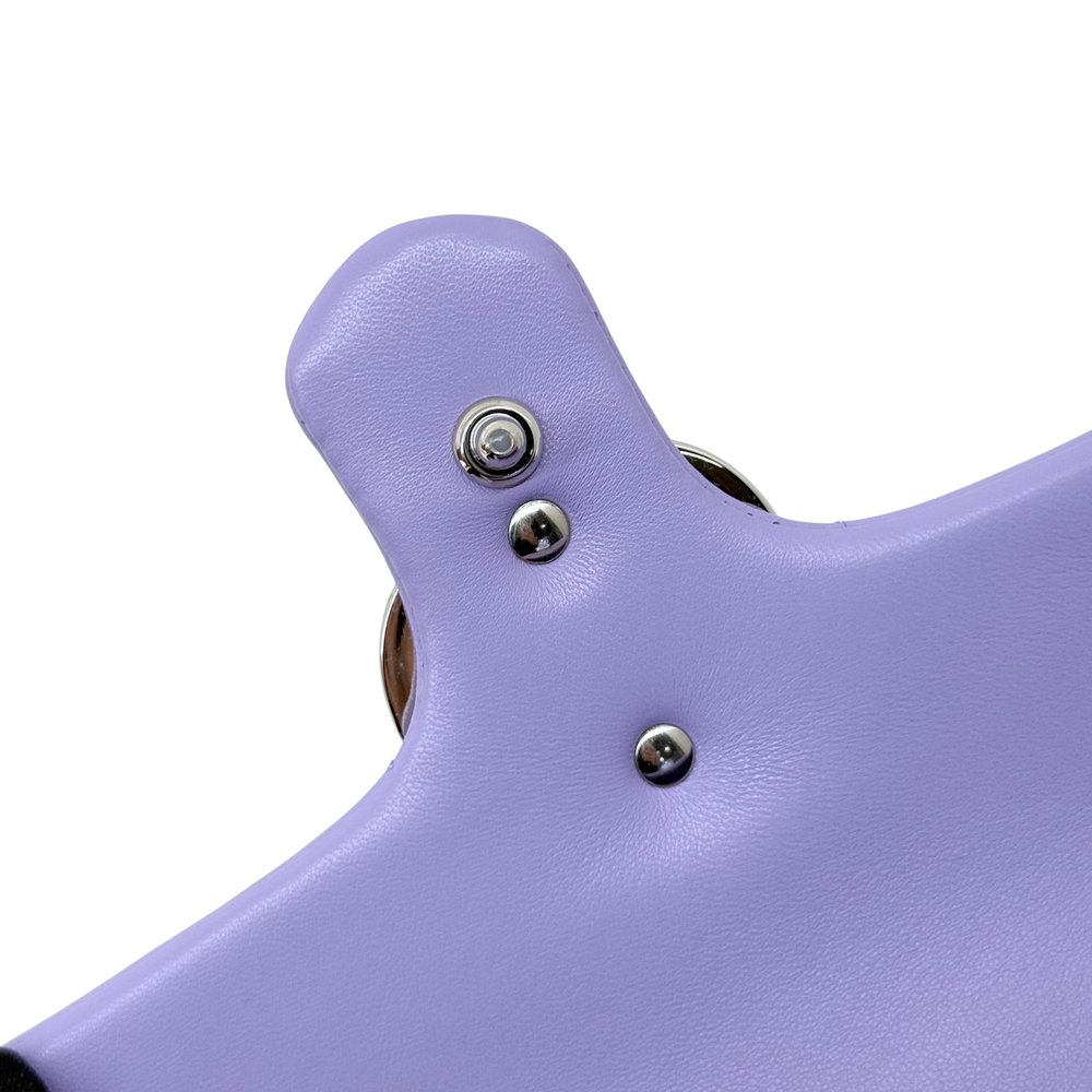 Lavender leather bag flap close-up with round metal snap buttons