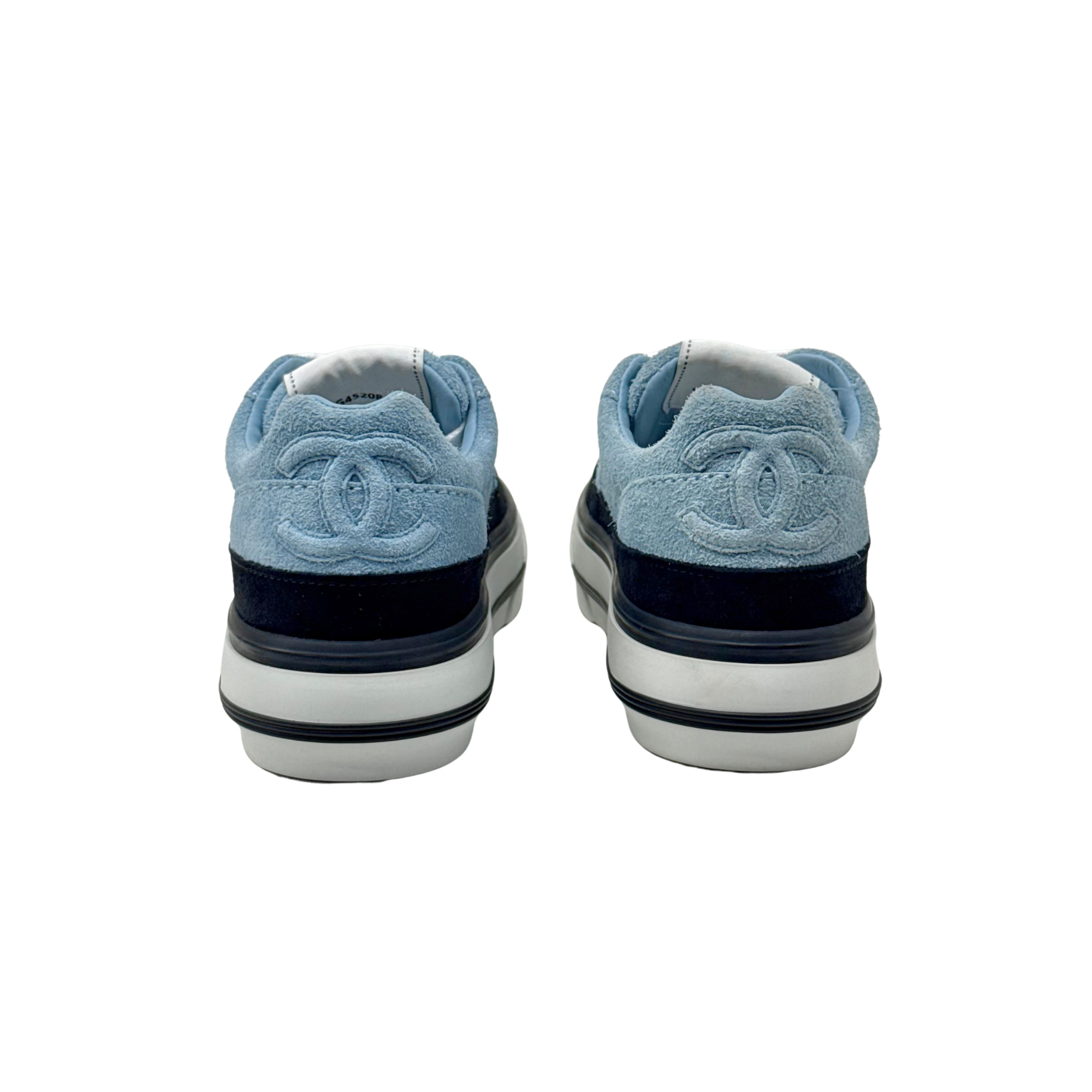 Pair of blue suede sneakers with white midsoles and black heel trim