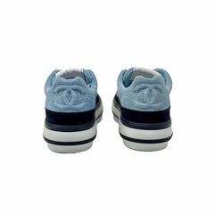 Pair of blue suede sneakers with white midsoles and black heel trim