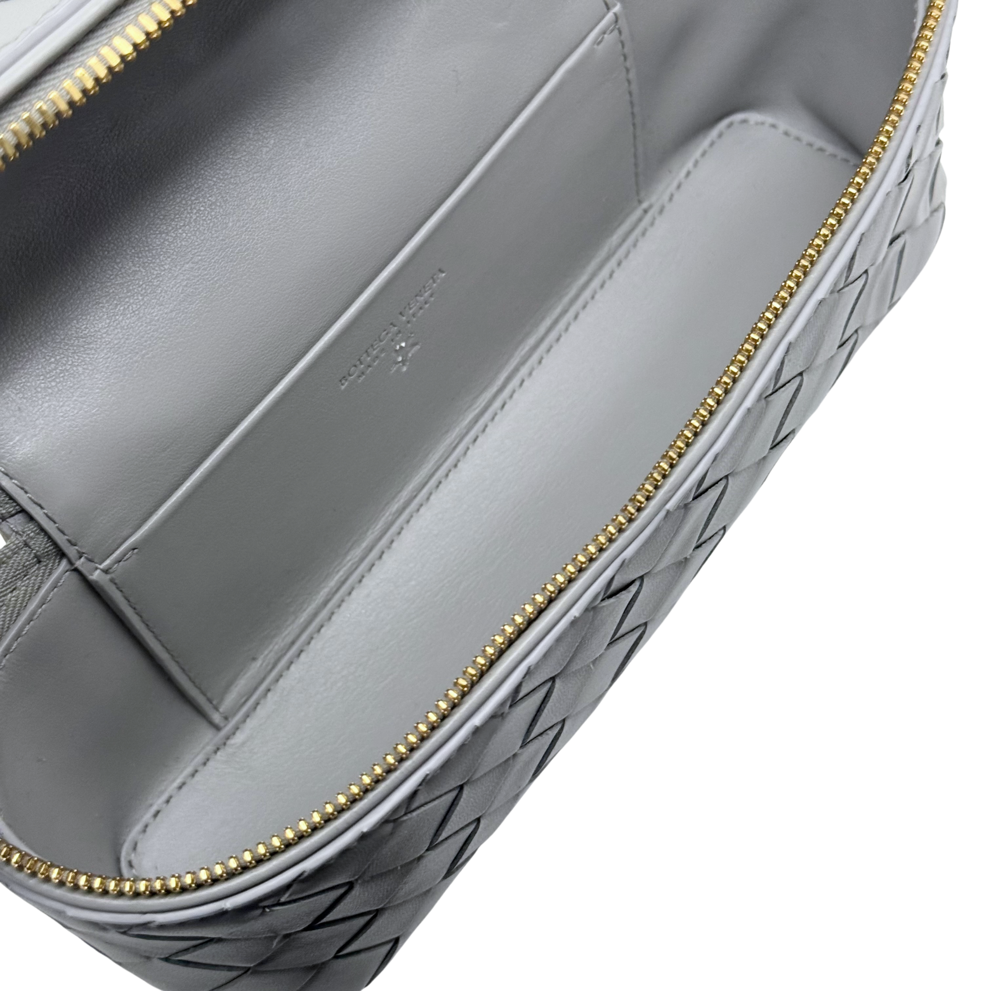 Bottega Veneta gray woven leather front panel with gold zipper trim and embossed logo.